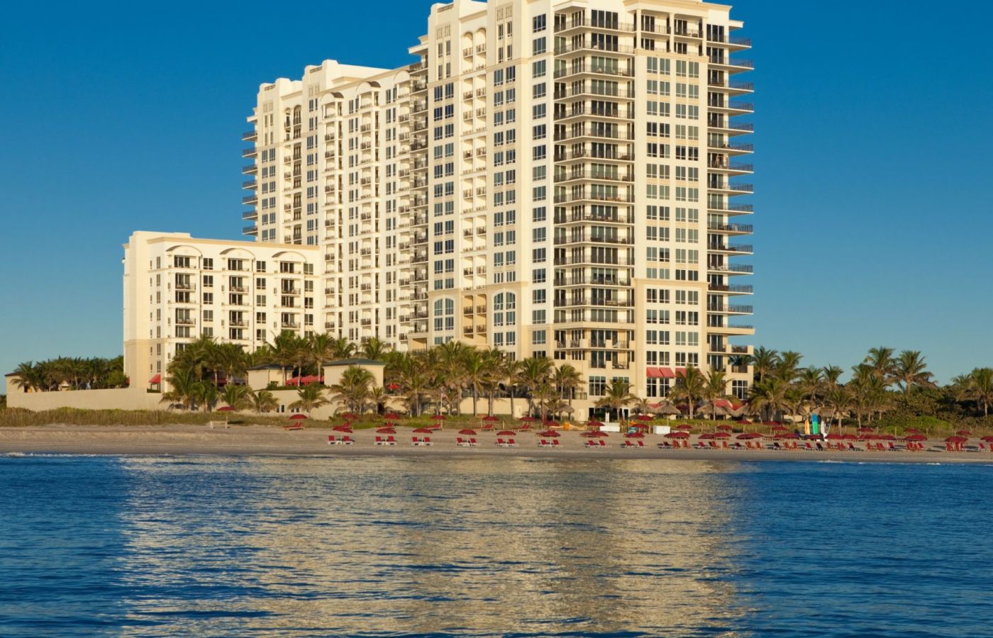 A Large White Building Next To A Body Of Water
